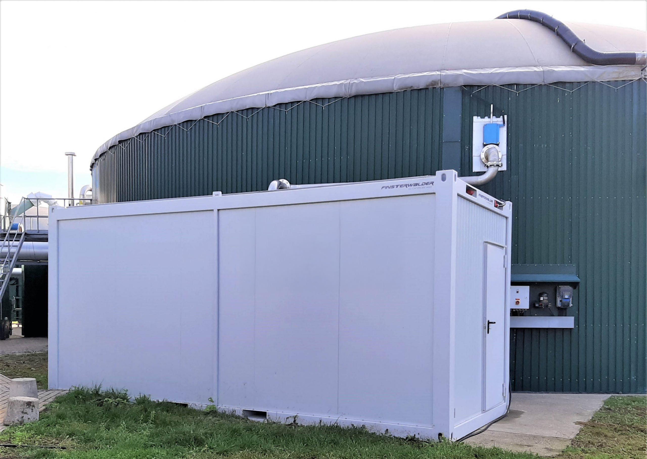 Klärwerk-Booster® im Container neben einem Biogas-Speicher